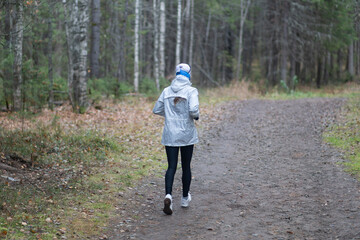 Fototapeta premium A woman is running in the forest, in the park.Fitness on the street.