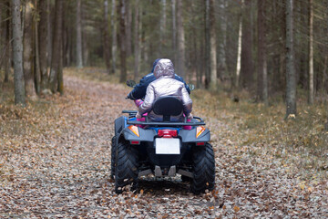 People ride an ATV in the autumn forest.Motor vehicles.