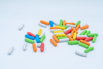 candies or pills on light background isolated