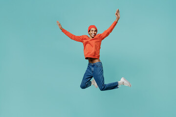 Fototapeta na wymiar Full body fun cool overjoyed young smiling happy african american man 20s wear orange shirt hat jump high with outstretched hands laugh isolated on plain pastel light blue background studio portrait