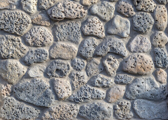 Wall is made of natural porous stone. Grey natural background. stone. Texture of natural porous . Topic - wall of house or fence in Mediterranean style