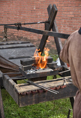 blacksmiths work with metal, heating it in a fire.