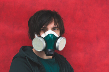 Man in respirator mask on red background. male portrait in gas mask