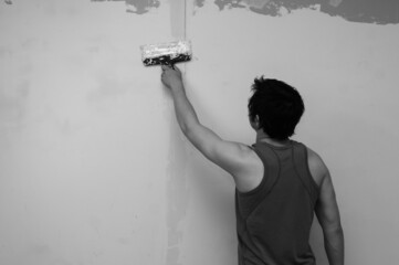 Man doing repairs. worker applies with putty to the wall. working process