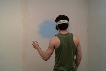 Man spraying paint on the wall. spray can in the hand. face in respirator