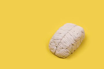 cerebro blanco en un fondo amarillo de estudio