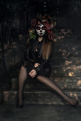 Obraz na płótnie Canvas a girl in a dead man's makeup and a black halloween dress