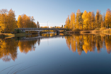 Autumn landscape by the lake and the reflection of trees in the water. Sunny day..Yellow foliage on trees in autumn