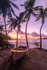 Obraz na płótnie Canvas Romantischer Sonnenuntergang am Strand Anse Takamaka Beach mit Blick auf ein gelbes Ruderboot auf der Insel Mahé auf den Seychellen