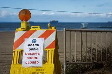 Ocean and shore closed sign on Huntington Beach after oil spill