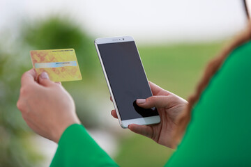 Woman with smartphone paying the bill and making online purchases