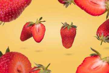 Creative composition with floating levitating ripe strawberries on a yellow background. Vitamins, fresh healthy food concept.