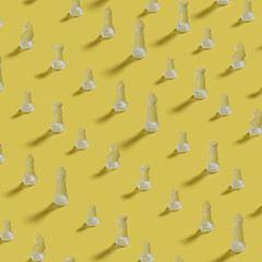 crystal chess pieces in rows in a pattern on a yellow background