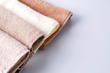 Clean cotton towels of pastel color on a light background.