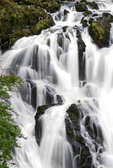 long exposure of white water cascading over the magnificent Rhaeadr Ewynnol Swallow Falls Waterfall, Betws-y-coed, Snowdonia National Park, Wales UK