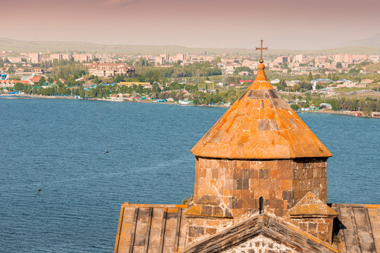 Close-up of the dome of the ancient Armenian Church with Sevan town on the background