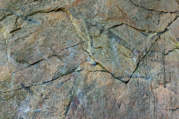Cracked granite stone texture. Solid rock close-up. Weathered rock. Climate change concept