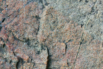 Cracked granite stone texture. Solid rock close-up. Weathered rock. Climate change concept