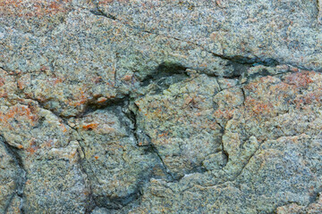 Cracked granite stone texture. Solid rock close-up. Weathered rock. Climate change concept