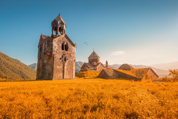 The chapel and bell tower stand alone on the territory of the Haghpat Monastery in Armenia. Sightseeing and pilgrimage concept - obrazy, fototapety, plakaty