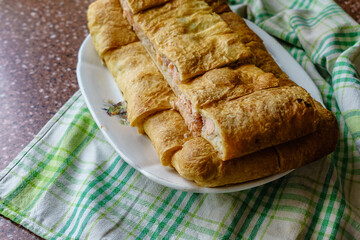 Fresh fried handmade cake with salmon on an old village plate.