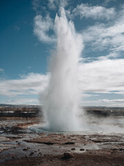 Fototapeta na wymiar Eruption of Strokkur geyser in Iceland. Winter cold colors, sun lighting through the steam