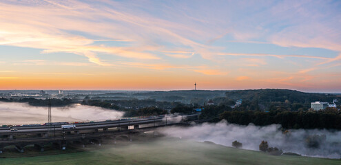 Naklejka premium Sunrise and the first rays of sunshine over the fog-covered Ruhr meadows in Duisburg, Germany