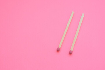 two matches on a pink paper table