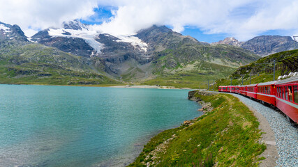 Bernina red train in and alpine lake