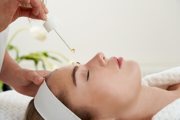 Face Skin Care. Closeup Of Beautiful Smiling Woman Receiving Serum Oil Treatment In Beauty Salon....