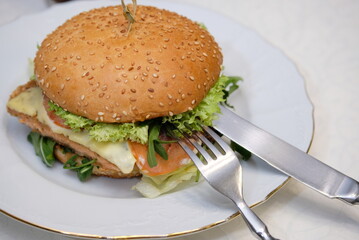 Juicy burger in a plate with cutlery