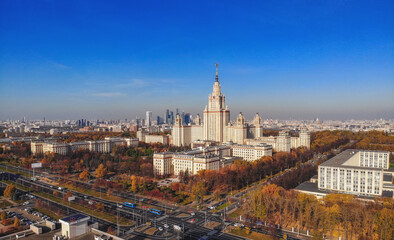 Fototapeta premium Aerial dron panoramic view of campus buildings of famous Moscow university under blue sky in early autumn