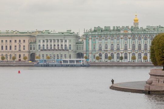 A man stands on the embankment of the Spit of Vasilyevsky Island. Winter Palace in the background. Saint-Petersburg, Russia.