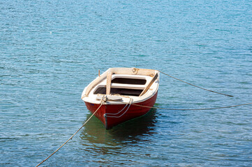 Small red boat rustic wooden anchored in Greece