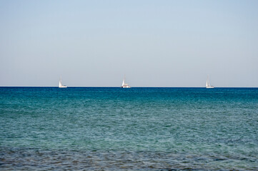 Obraz premium 3 White boats sailing in the open blue aegean sea in Greece