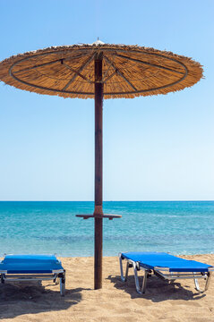Two sun beds under sun umbrella at the beach. Zephyros beach. Greece