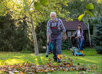 Father and daughter working in garden in autumn