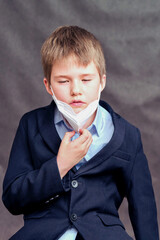 A boy in a medical mask on his face, copy space on a black studio background