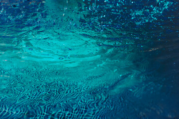 Bright blue water background with a green tint. Abstract neon water background