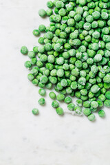 Frozen green peas close-up on a white background