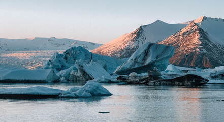 Aerial Drone view black volcanic beach of Jokulsarlon glacier lagoon in Winter during sunset.