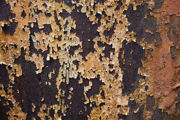 Old paint peeling away from rusted iron surface. Macro texture.