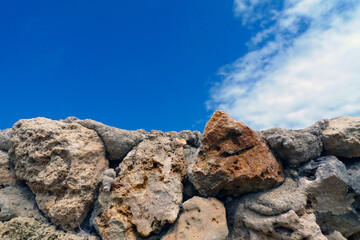 Rough stone wall with blue sky and white clouds in the background of Kenya Africa for copy space