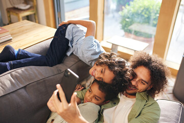 Obraz na płótnie Canvas Father and sons taking selfie on phone