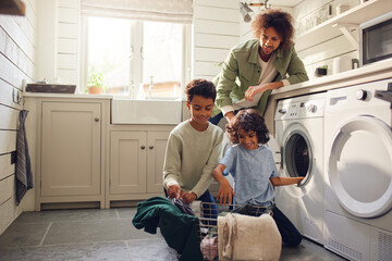 Boys doing laundry with father watching - obrazy, fototapety, plakaty