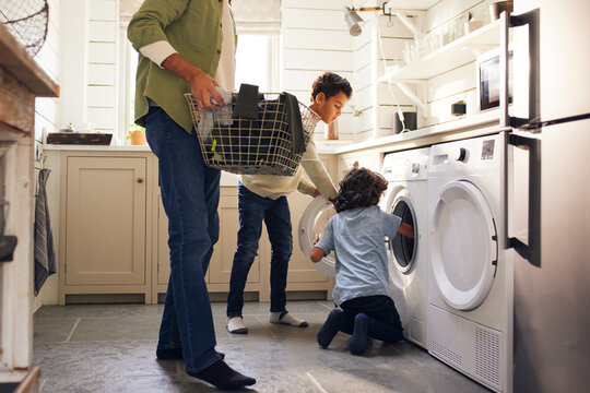 Boys doing laundry with father holding basket