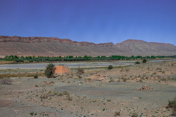 Africa Morocco desert Atlas mountains nature rock landscape with river palm under blue sky hot weather 