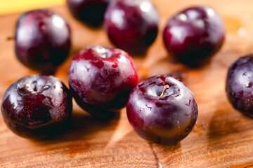Fresh black plums on cutting board