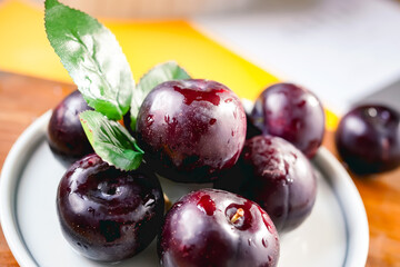 Fresh black plums on cutting board