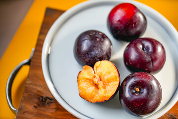 Fresh black plums on cutting board